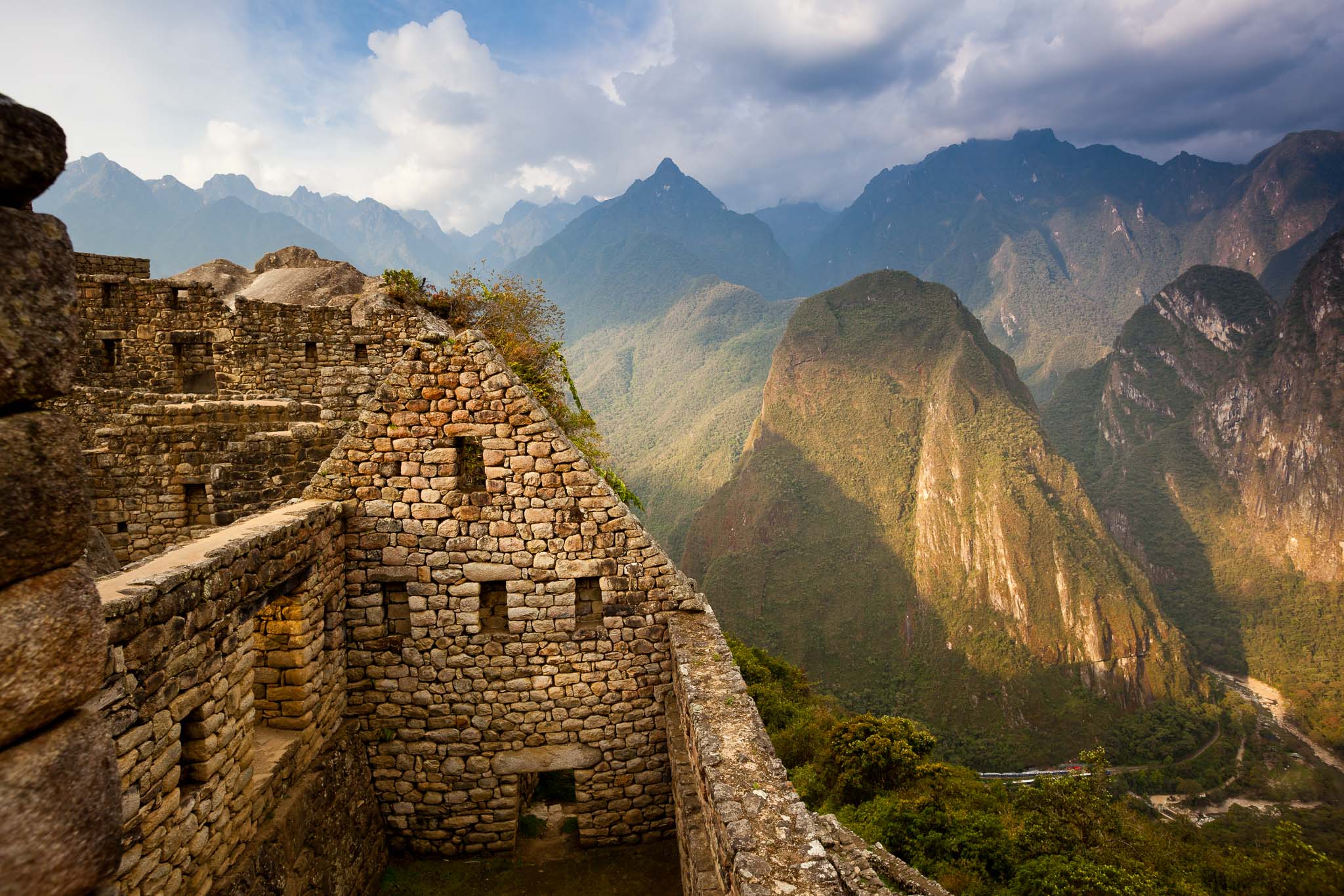 View of Machu Picchu - the Lost City of the Incas - located in the Vilcanota mountain range in south-central Peru.  Machu Picchu is a UNESCO site and is located on the steep jungle-covered slopes of this region.  The weather can change in minutes from clouds and rain to sunshine and warm temperatures. People can still trek to this city - three days away through the Vilcanota range.